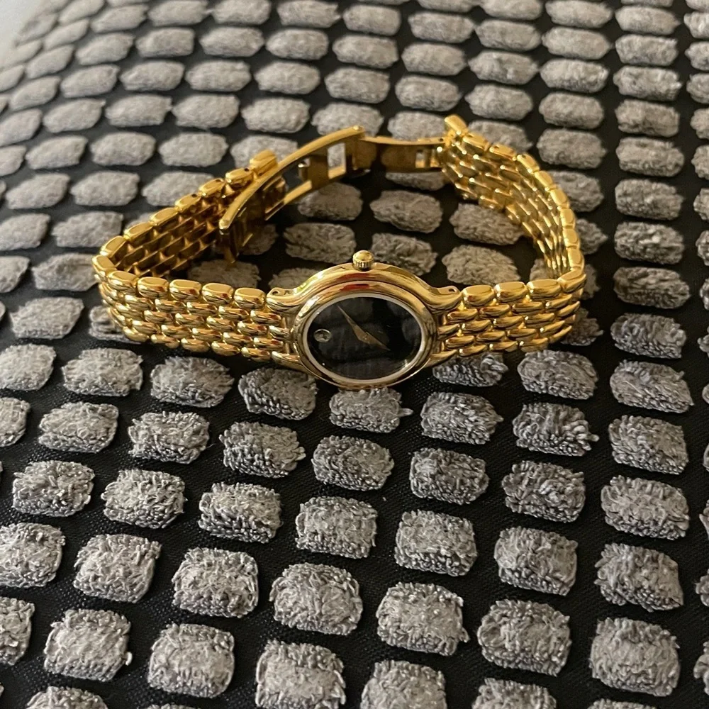Movado black dial, gold tone bracelet strap watch